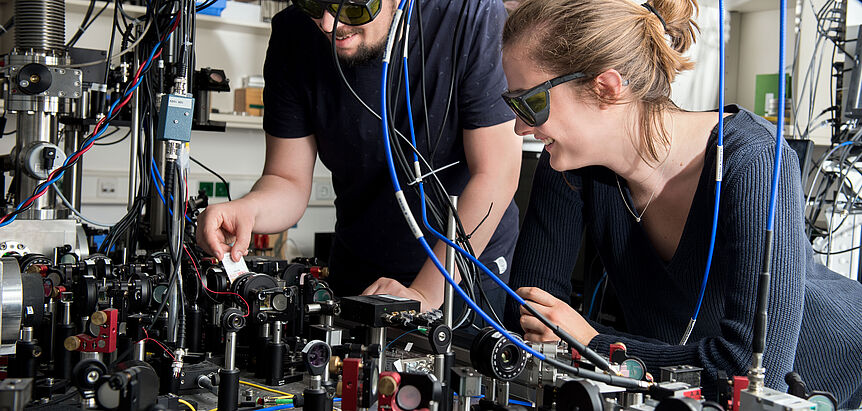 Studierend der Physik arbeiten mit Schutzbrille an Maschine